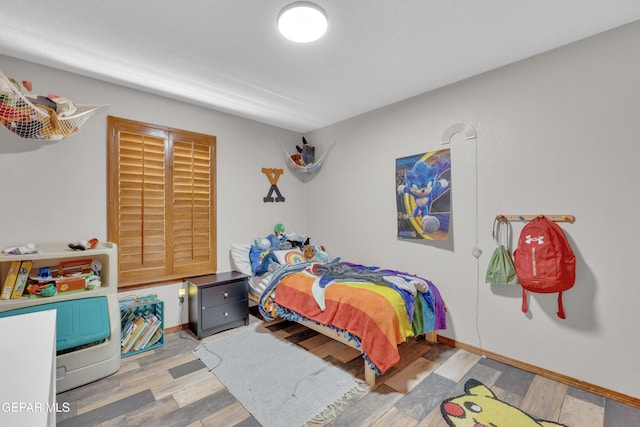 bedroom with baseboards and wood finished floors