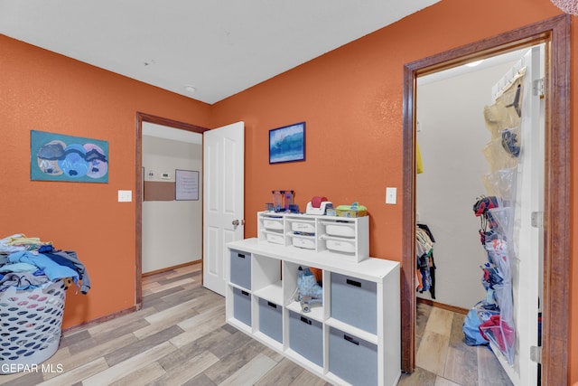 interior space featuring light wood-type flooring and baseboards