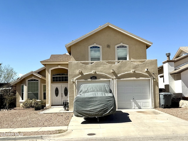 view of front facade with concrete driveway, a garage, and stucco siding