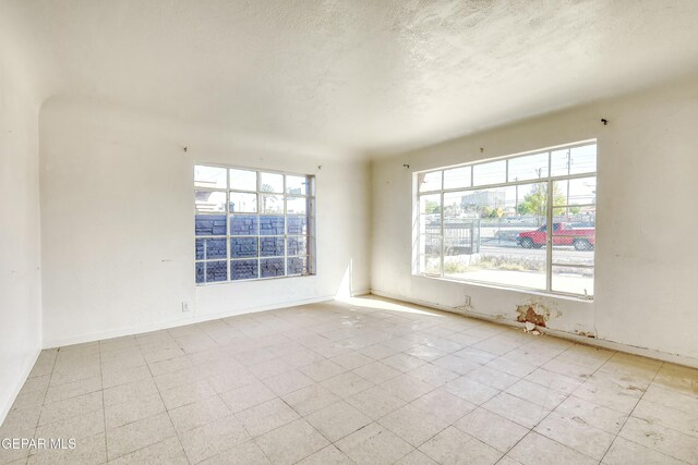 5930 Cleveland Ave, El Paso, TX 79905 - spare room with a textured ceiling, baseboards, and tile patterned floors