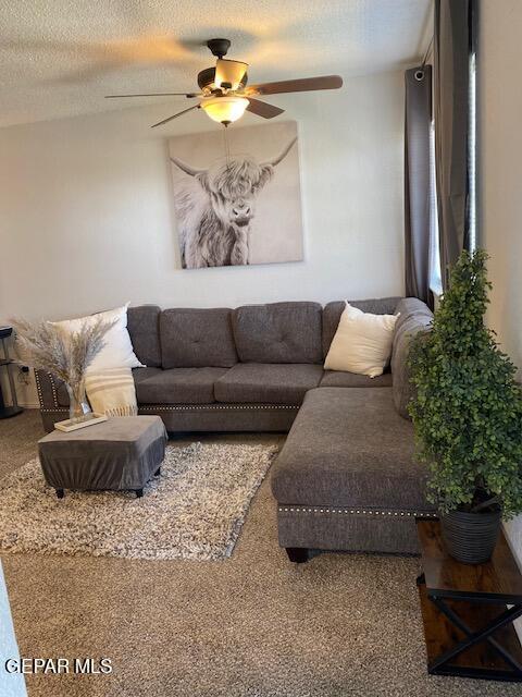 living room featuring a ceiling fan and a textured ceiling