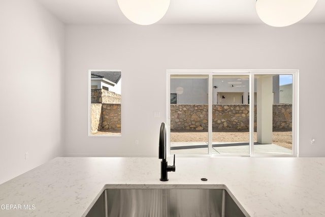 kitchen featuring light stone countertops and a sink