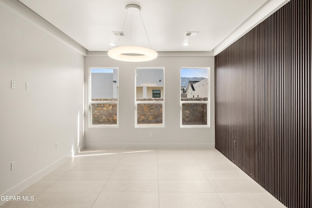 tiled spare room featuring visible vents and baseboards