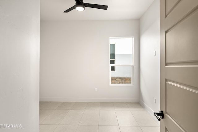 spare room with light tile patterned floors, baseboards, and ceiling fan