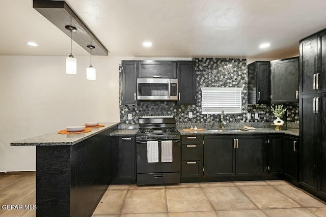 kitchen featuring dark stone counters, a peninsula, a sink, black range with gas cooktop, and stainless steel microwave