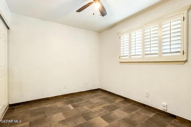 empty room featuring baseboards and ceiling fan