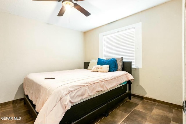 bedroom with a ceiling fan and baseboards