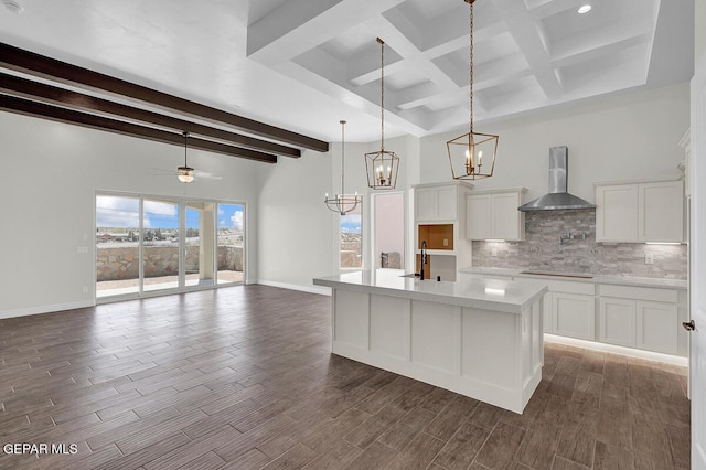 kitchen with tasteful backsplash, wall chimney range hood, wood tiled floor, light countertops, and white cabinets