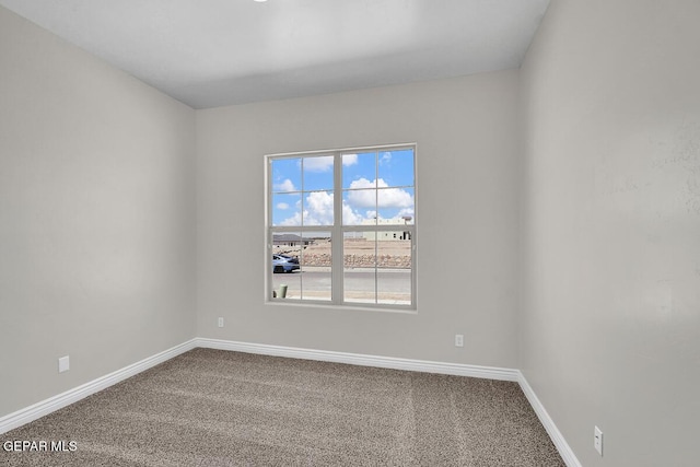 carpeted empty room featuring baseboards