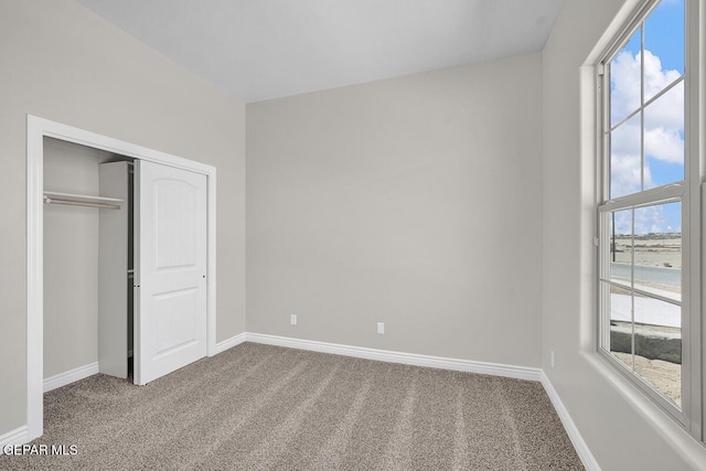 unfurnished bedroom featuring a closet, baseboards, and carpet floors