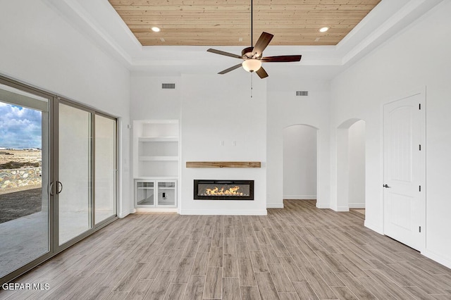 unfurnished living room featuring a tray ceiling, visible vents, wood ceiling, and wood finished floors