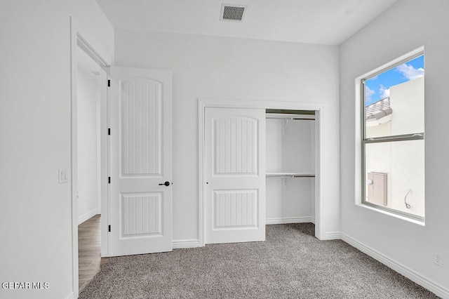 unfurnished bedroom featuring visible vents, baseboards, a closet, and carpet flooring