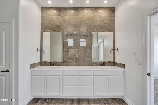 bathroom featuring double vanity, wood tiled floor, and a sink