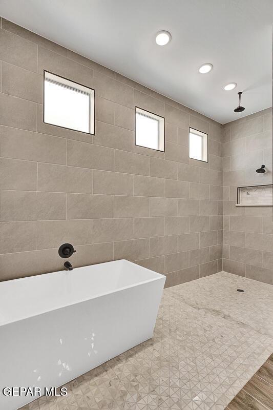 bathroom featuring recessed lighting, tiled shower, and a freestanding bath