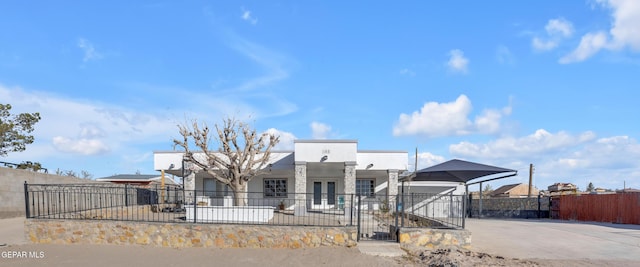 view of front of home with a fenced front yard, stucco siding, and driveway