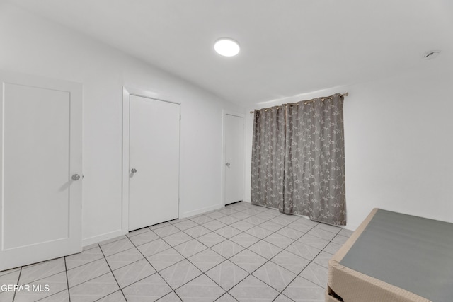 unfurnished bedroom with light tile patterned floors