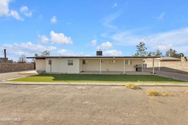 view of front of house with a patio, a front lawn, and fence