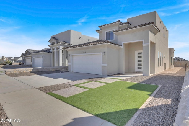 mediterranean / spanish-style home featuring a tiled roof, stucco siding, an attached garage, and driveway