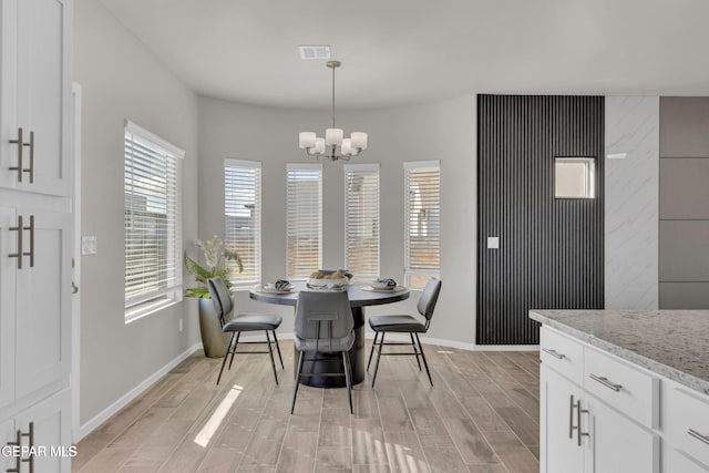 dining area featuring a chandelier, visible vents, baseboards, and wood finish floors