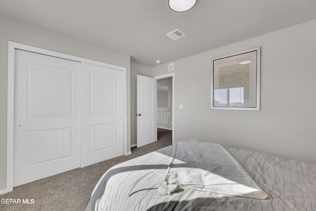 bedroom with carpet, visible vents, and a closet