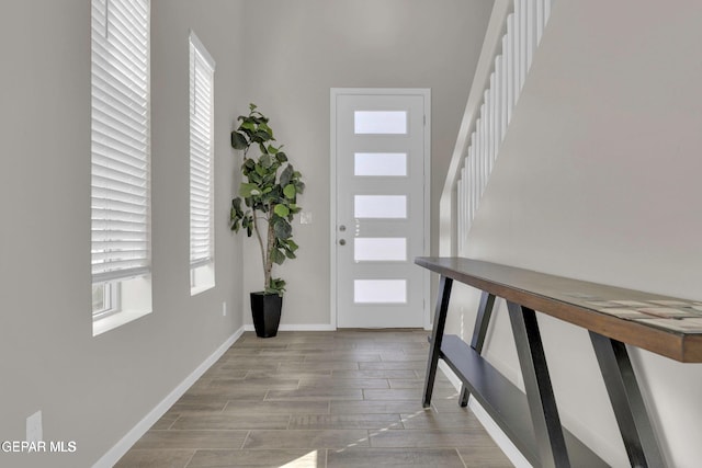 entryway featuring stairway, baseboards, and wood tiled floor