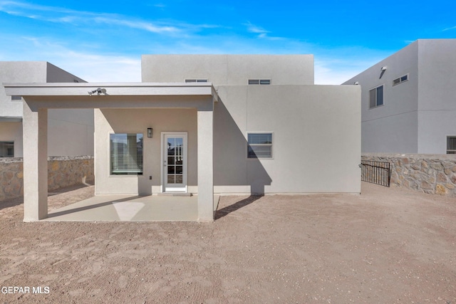 back of house featuring stucco siding, a patio, and visible vents