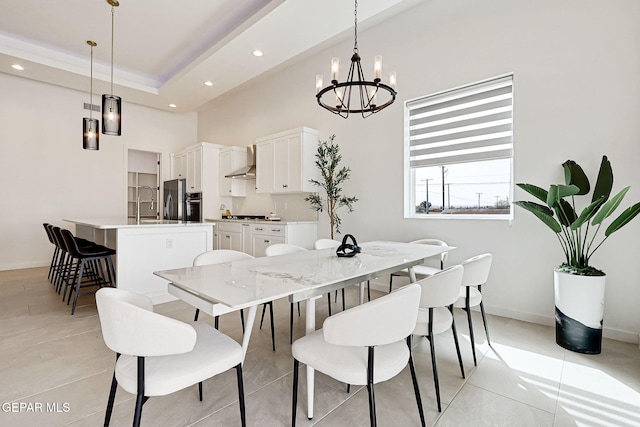 dining space with baseboards, an inviting chandelier, a tray ceiling, recessed lighting, and a towering ceiling