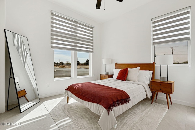 bedroom featuring light tile patterned floors, a ceiling fan, and baseboards