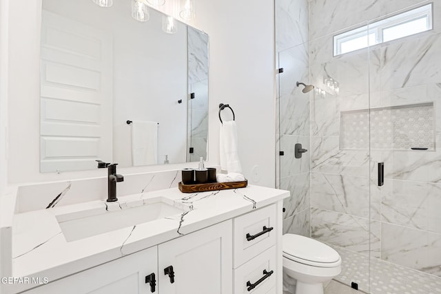 bathroom with a shower stall, toilet, and vanity