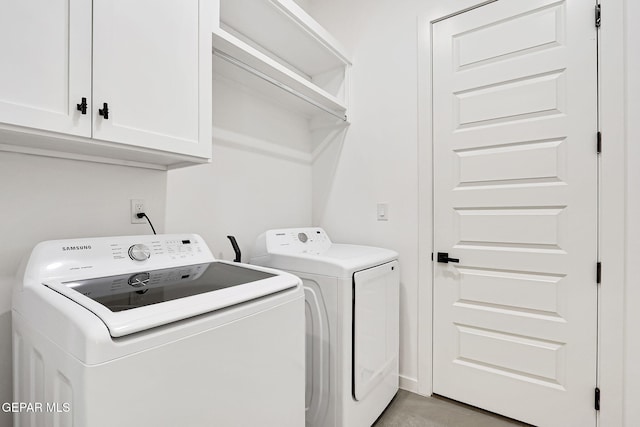 washroom featuring washer and dryer and cabinet space