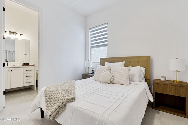 bedroom with light tile patterned floors and connected bathroom