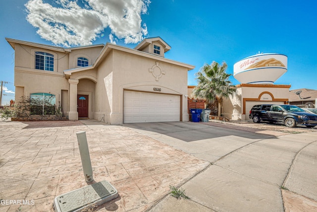 view of front facade featuring stucco siding, concrete driveway, and a garage