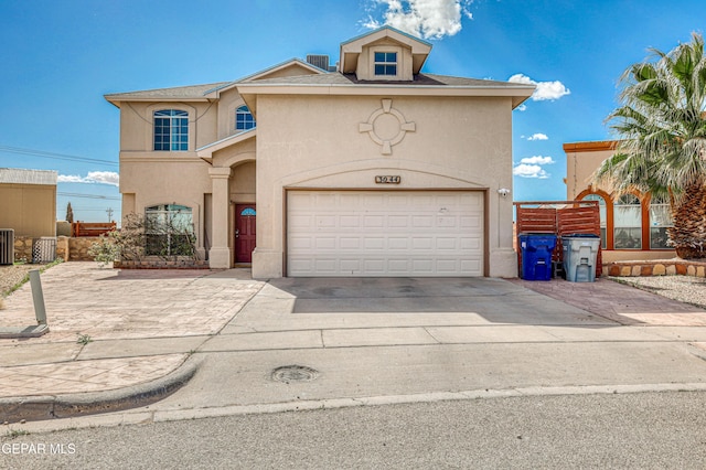 view of front of home featuring fence, central air condition unit, stucco siding, a garage, and driveway