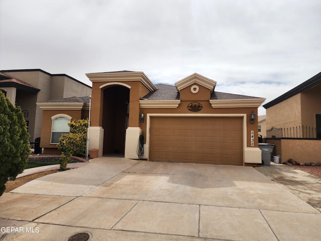 view of front of home featuring stucco siding, driveway, and a garage