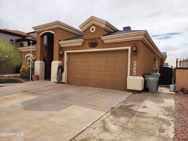 view of front of home with a gate, a garage, driveway, and stucco siding