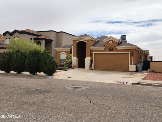 mediterranean / spanish home featuring concrete driveway, a garage, and stucco siding