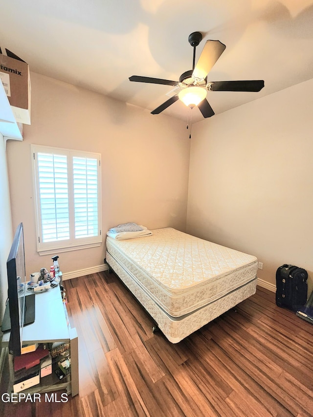 bedroom with ceiling fan, baseboards, and wood finished floors