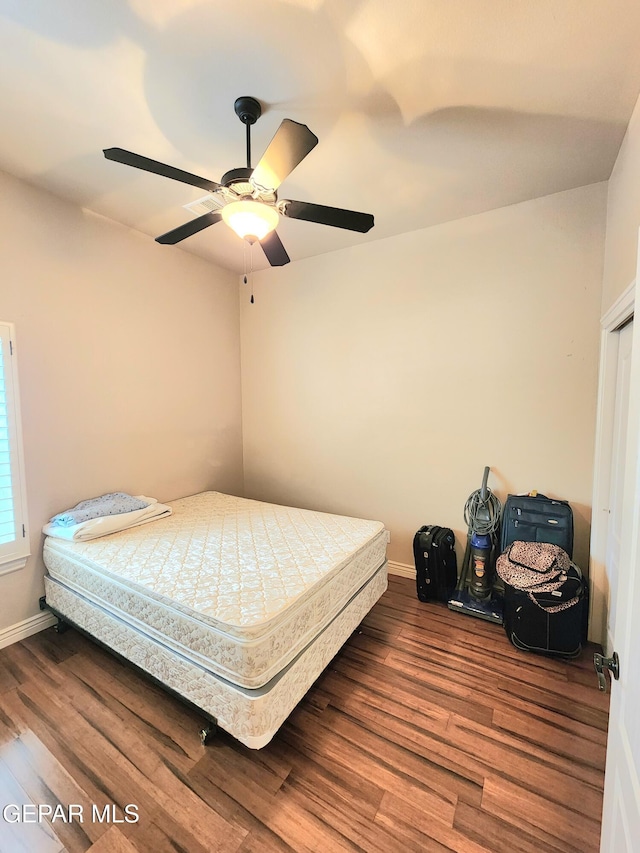 bedroom with a ceiling fan, baseboards, and wood finished floors