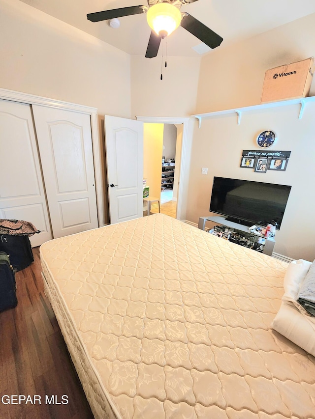 bedroom with a closet, ceiling fan, and dark wood-style flooring