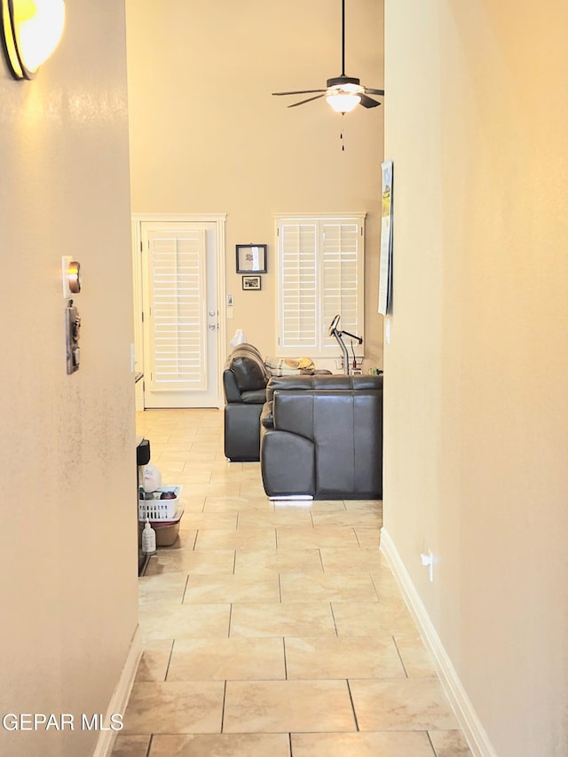 hallway with a high ceiling and baseboards