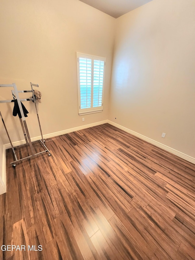 unfurnished room featuring dark wood finished floors and baseboards