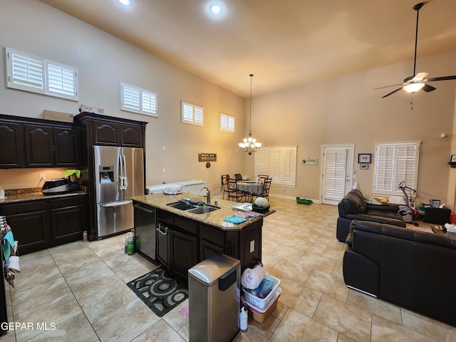 kitchen with dishwashing machine, a sink, stainless steel fridge, ceiling fan with notable chandelier, and open floor plan