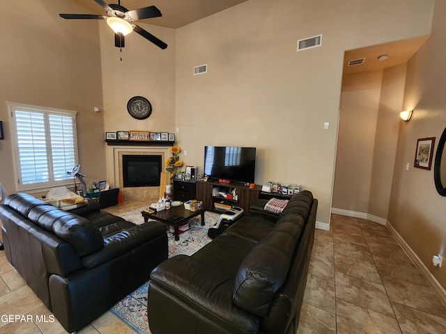 living room featuring tile patterned flooring, a ceiling fan, visible vents, and a tile fireplace