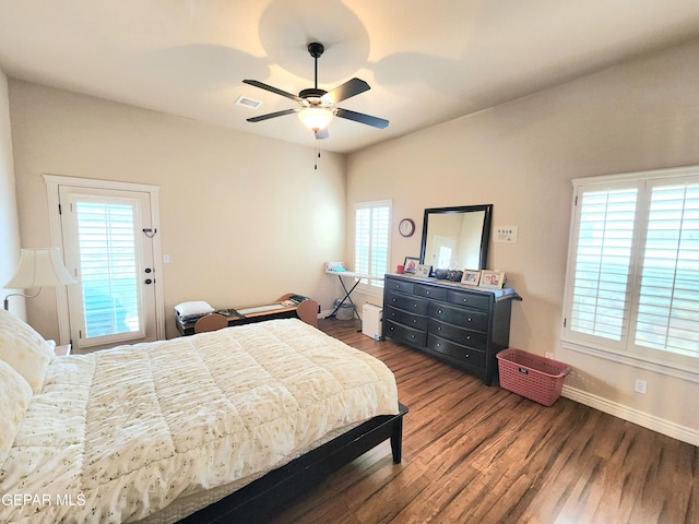 bedroom featuring ceiling fan, wood finished floors, visible vents, and baseboards