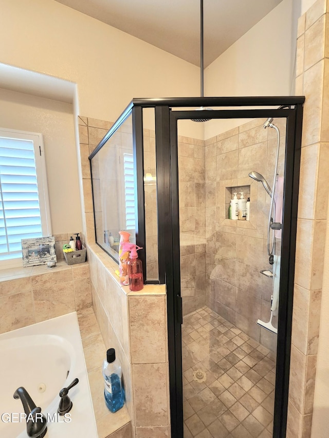 full bathroom featuring a sink, a shower stall, a jetted tub, and vaulted ceiling