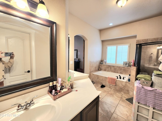 full bath with a stall shower, a bath, vanity, and tile patterned flooring