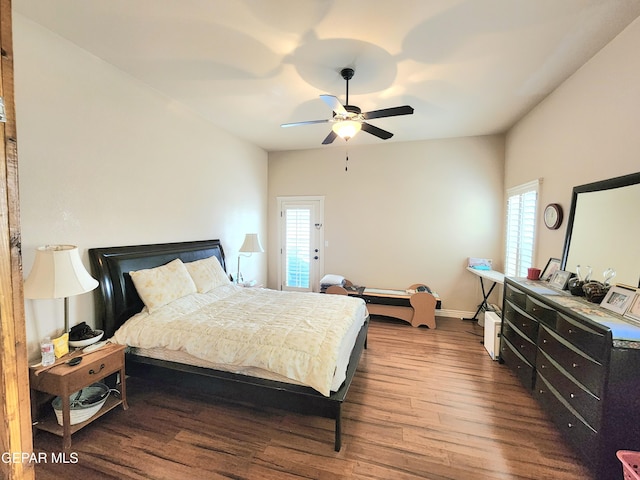 bedroom with ceiling fan, baseboards, and dark wood-style floors