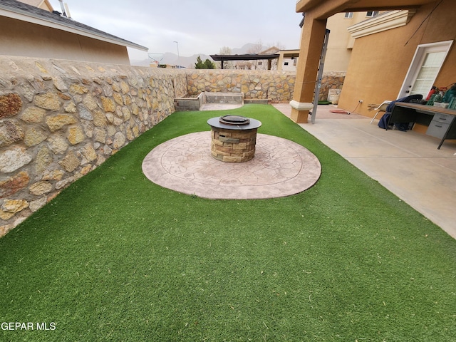 view of yard with a patio, a fire pit, and fence