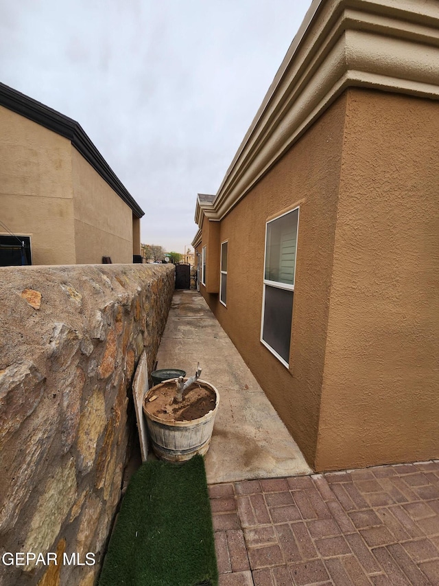 view of side of home with a patio area and stucco siding