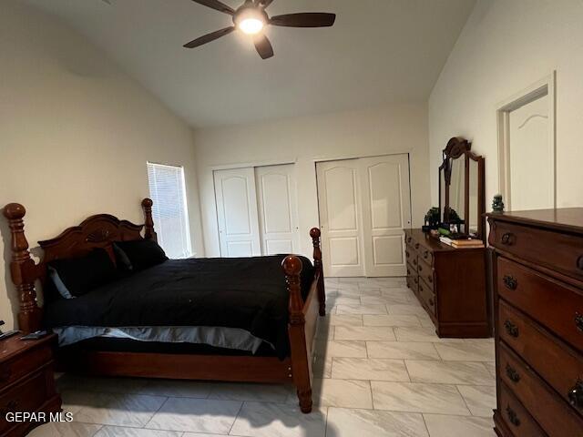 bedroom featuring multiple closets, a ceiling fan, and vaulted ceiling